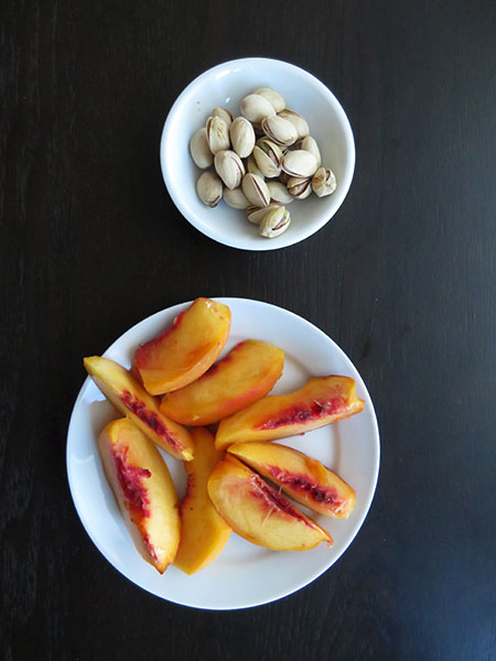 Snack of Roasted Pistachio Nuts in the Shell With a Fresh Sliced Peach