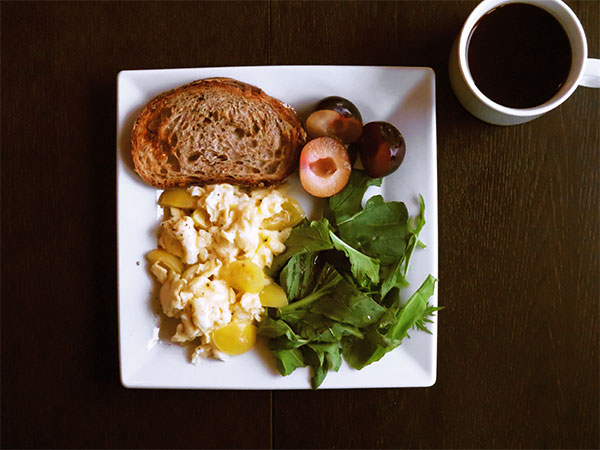 Tomato and Cheese Egg Scramble With Mixed Green Salad, Multigrain Toast, and Plums