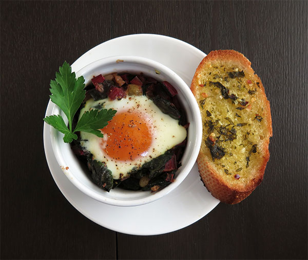 Baked Eggs in Sautéed Chard with Garlic Bread