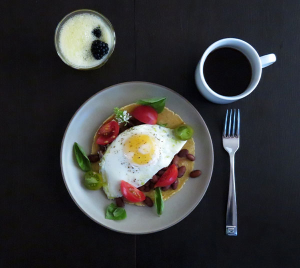 Huevos Rancheros Made With Homemade Corn Tortillas, Pinto Beans, Cherry Tomatoes and Basil.